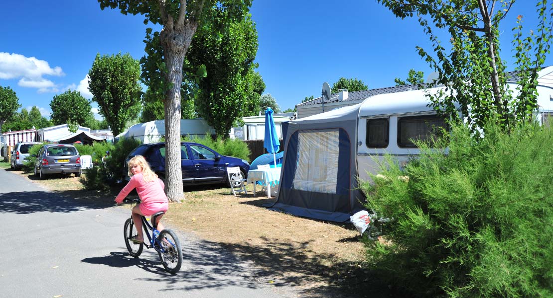 Een kind op een fiets in de gangpaden van camping La Plage in de Vendée