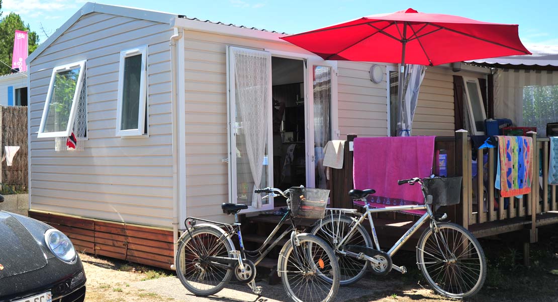 Bikes in front of the terrace of a mobile home at the campsite by the sea in Saint-Hilaire