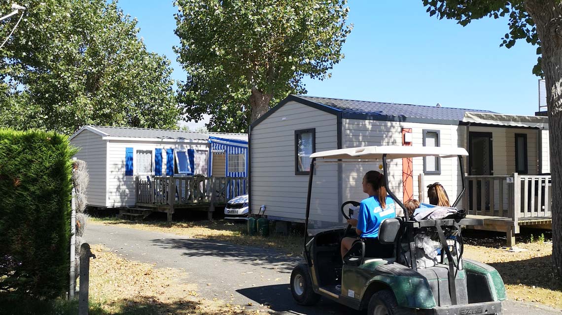 Electric cart in front of the mobile homes at La Plage campsite in Saint-Hilaire