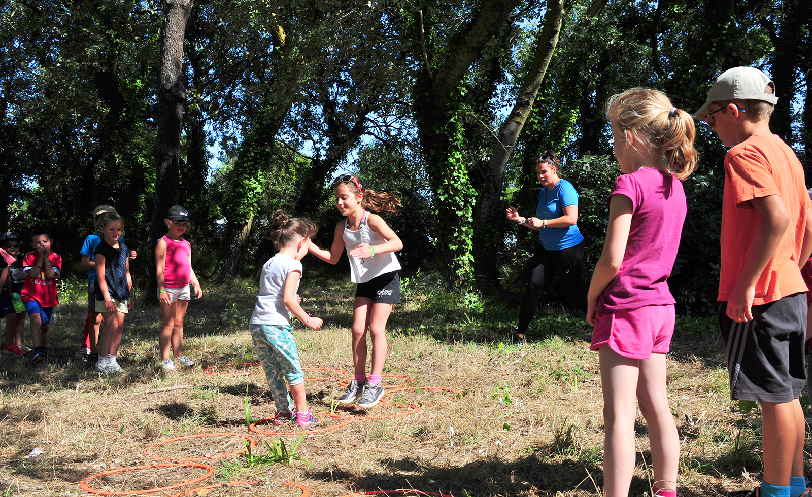 Children in a clearing with the children's club at La Prairie campsite in Saint-Hilaire