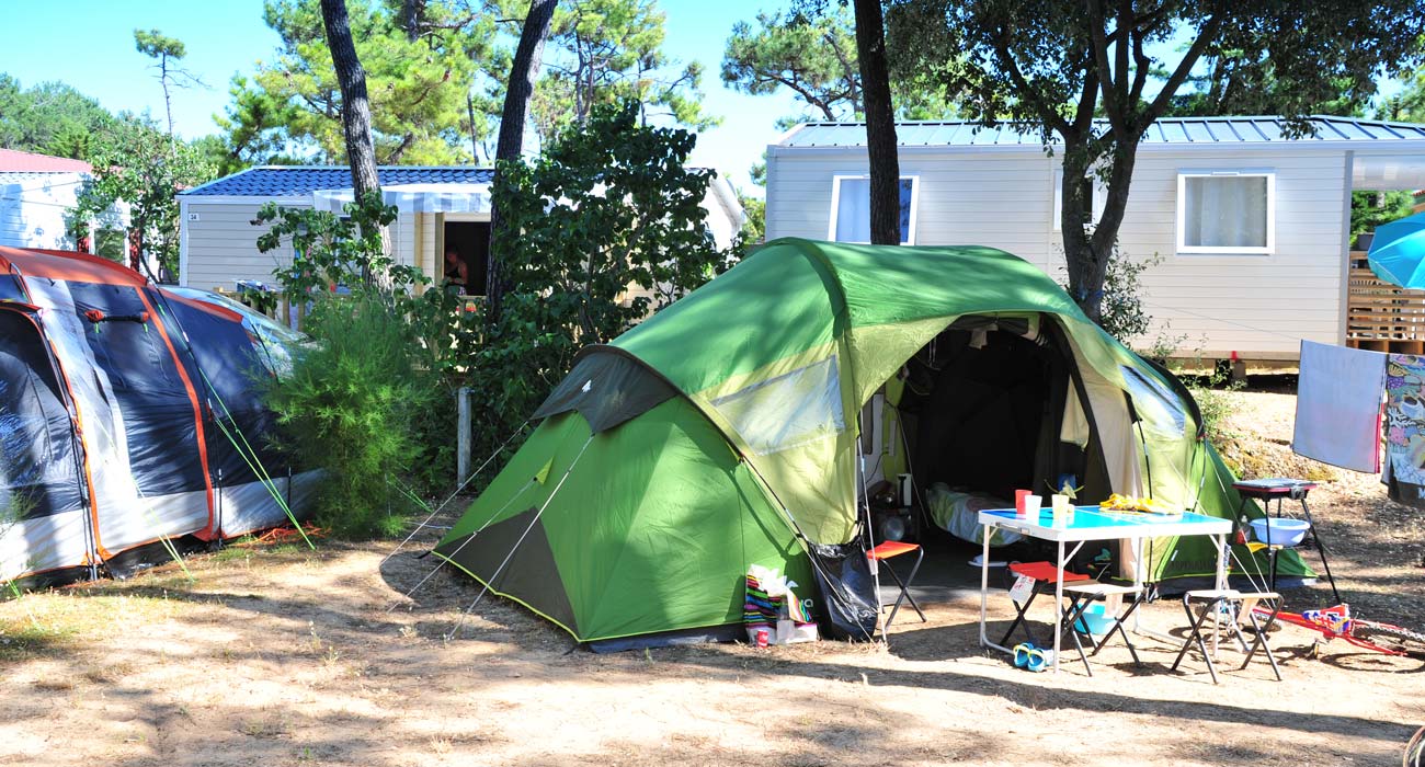 Kampeerplaats met heggen en bomen op camping Le Clos des Pins 85
