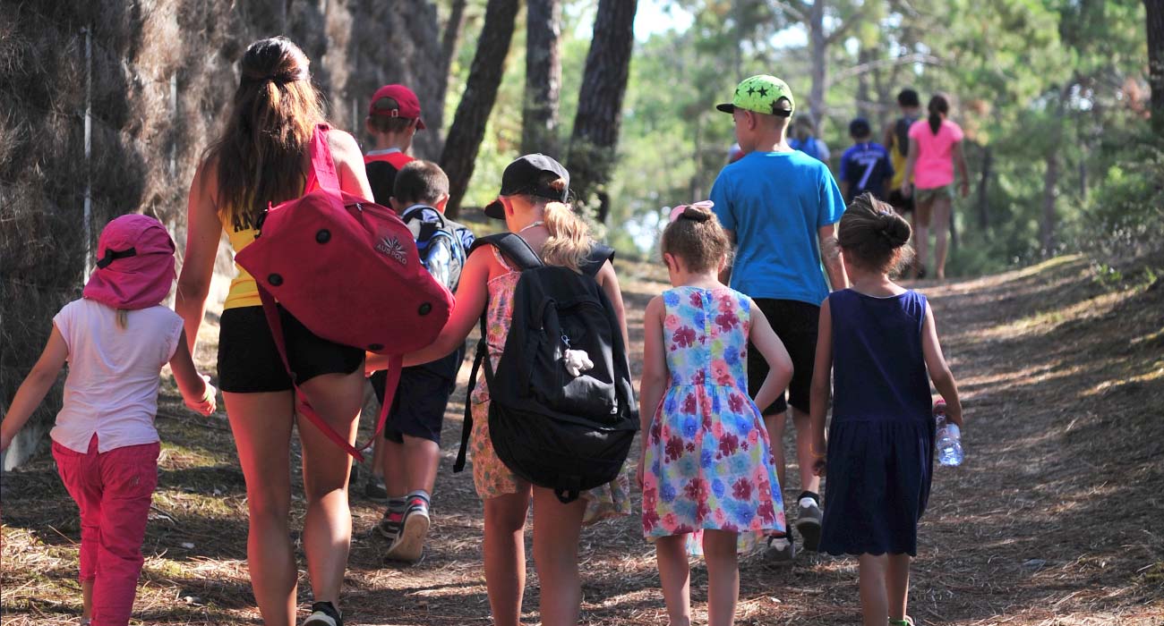 Kinderen met kinderclubleidsters op een pad in het bos bij de camping in de Vendée