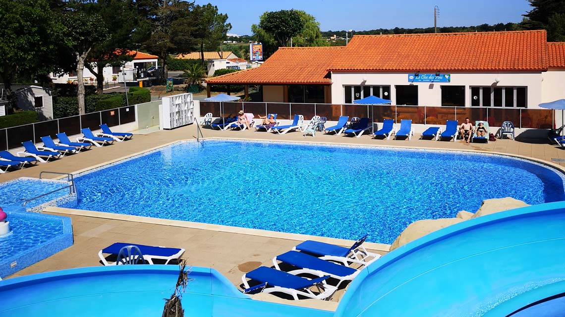 The pool of the outdoor aquatic area with its deckchairs at the campsite in Vendée