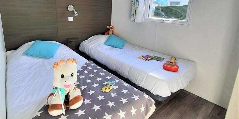 Single beds and toys in the children's room of a 6-person mobile home in Saint-Hilaire