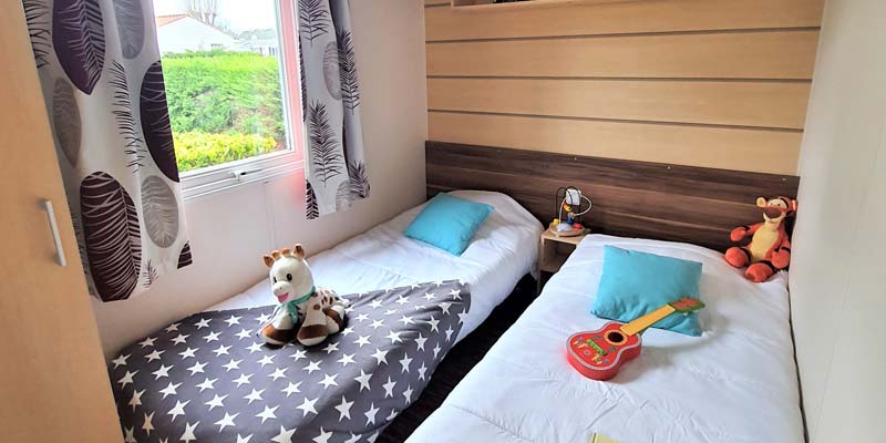 Twee eenpersoonsbedden in de slaapkamer van een comfortabele stacaravan in de Vendée