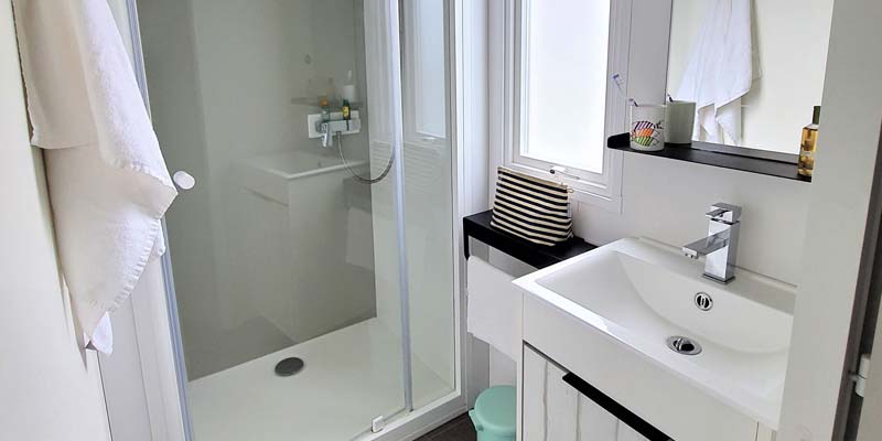 Salle de bain avec douche et lavabo dans un mobil-home au camping La Plage à Saint-Hilaire