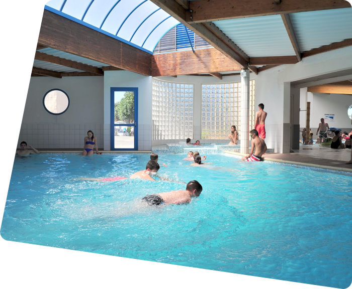 Children swimming in the covered aquatic area of the campsite in Saint-Hilaire