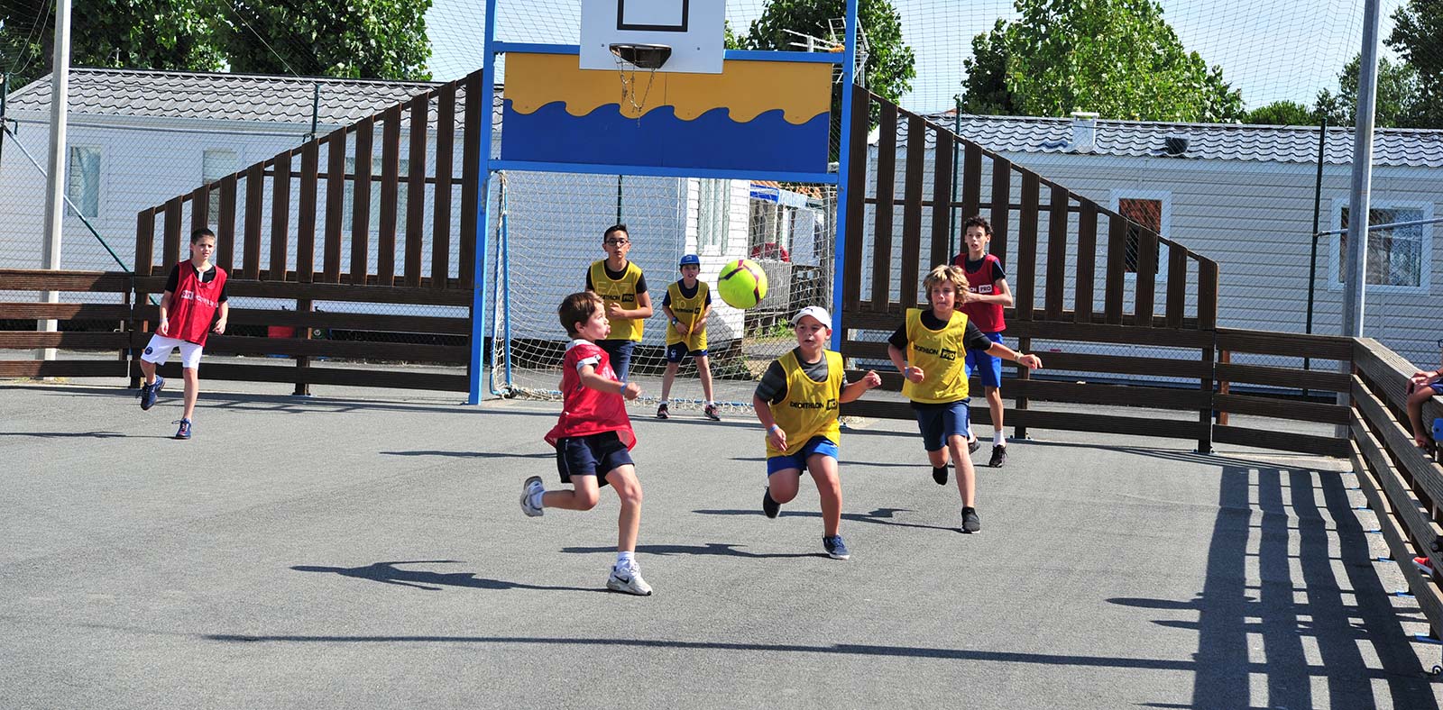 Terrain multisport avec enfants jouant au football au camping à Saint-Hilaire