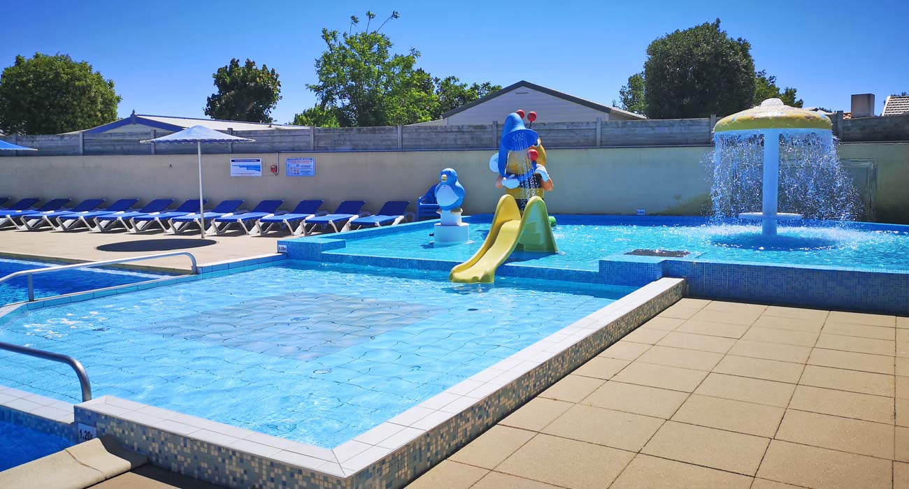 Paddling pool with water jets and mini-slides for children at the campsite in Saint-Hilaire