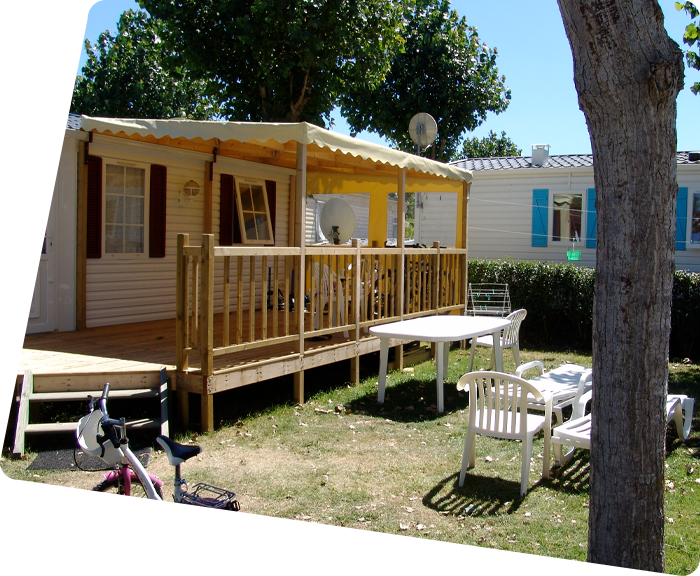 Terras van een stacaravan en tuinmeubelen op camping La Prairie in Saint-Hilaire