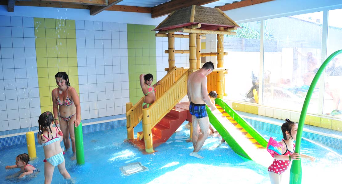 Jeux aquatiques dans l'espace couvert de la piscine du camping en Vendée