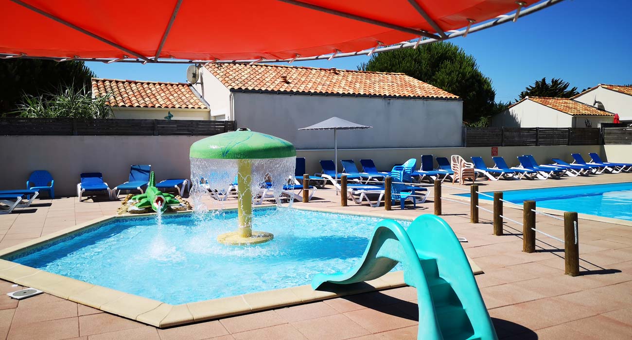 Paddling pool with water jets and mini-slides for children at the campsite in Saint-Hilaire