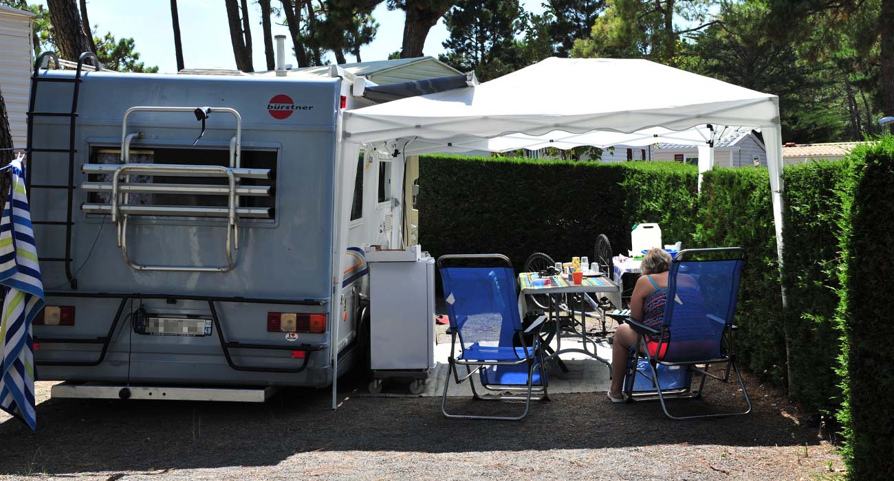 Family of campers in front of a motorhome at Le Clos des Pins campsite