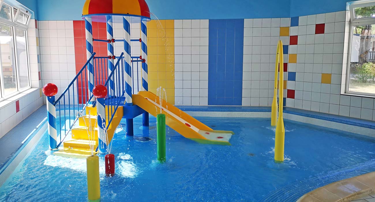 Espace aquatique couvert avec pataugeoire pour enfants au camping à Saint-Hilaire