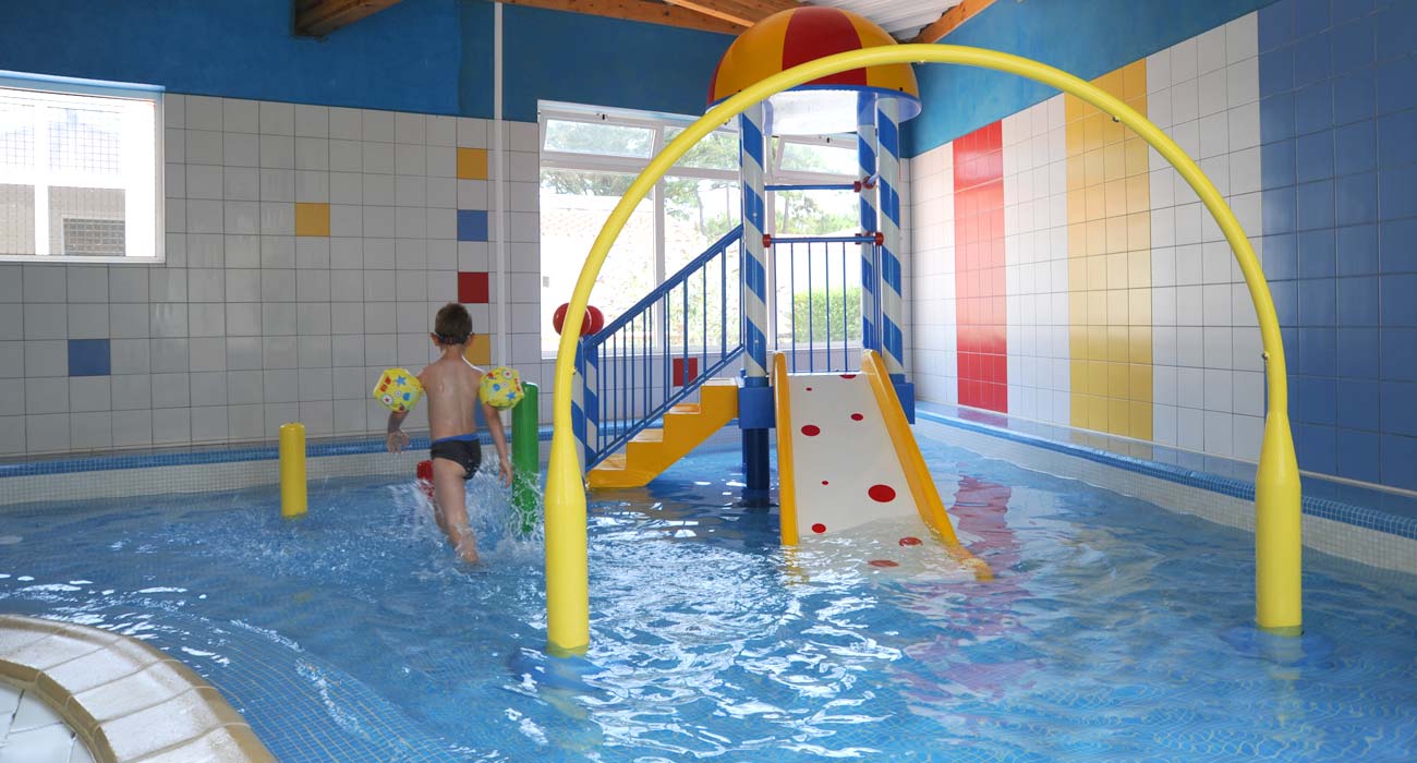 Mini-slides in the paddling pool of the covered swimming pool at Le Clos des Pins 85 campsite