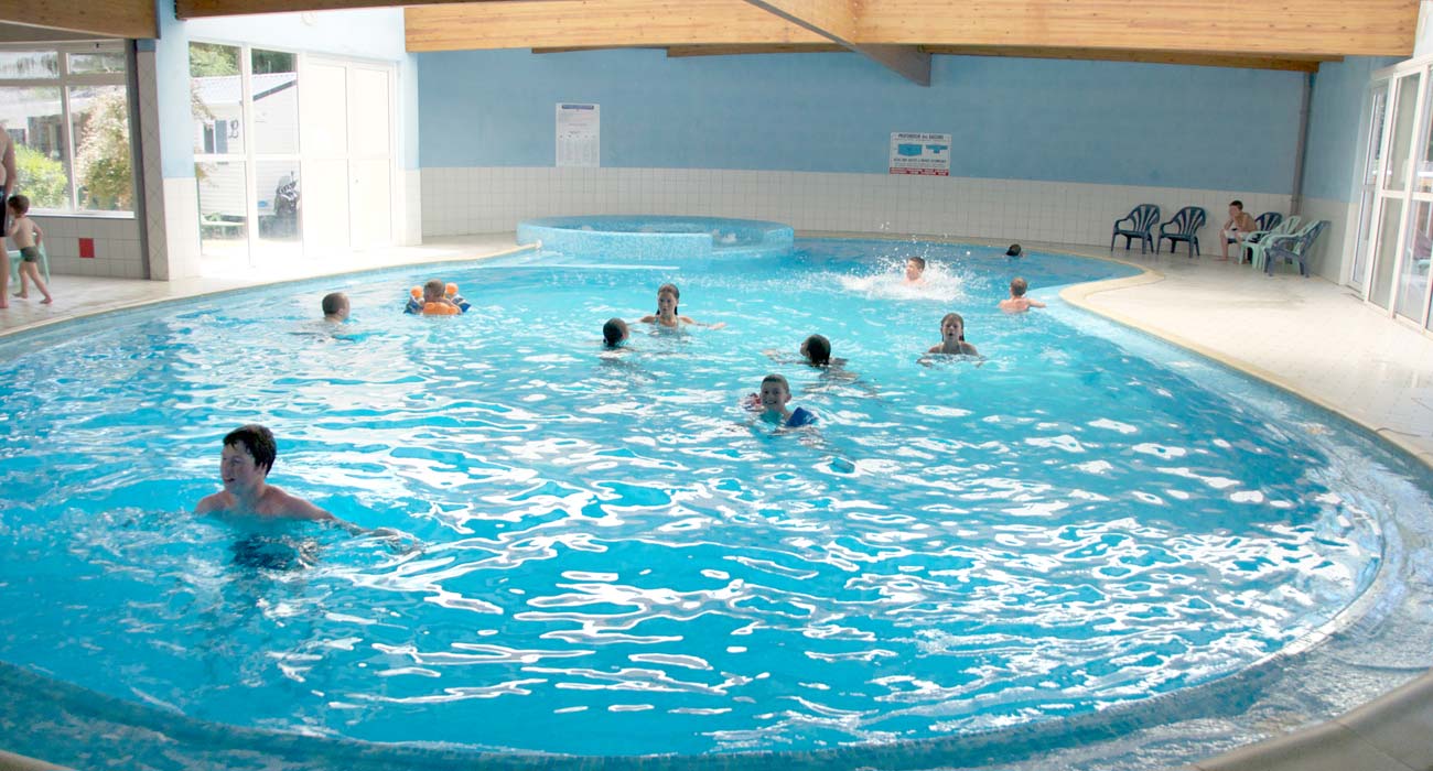 Kampeerders zwemmen in het overdekte en verwarmde zwembad van de camping in Saint-Hilaire