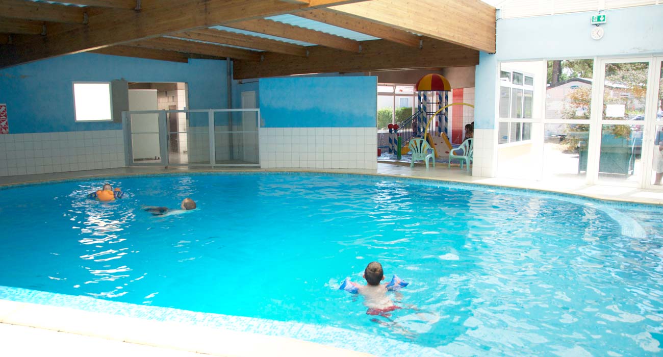 Enfants nageant dans l'espace aquatique couvert du camping à Saint-Hilaire