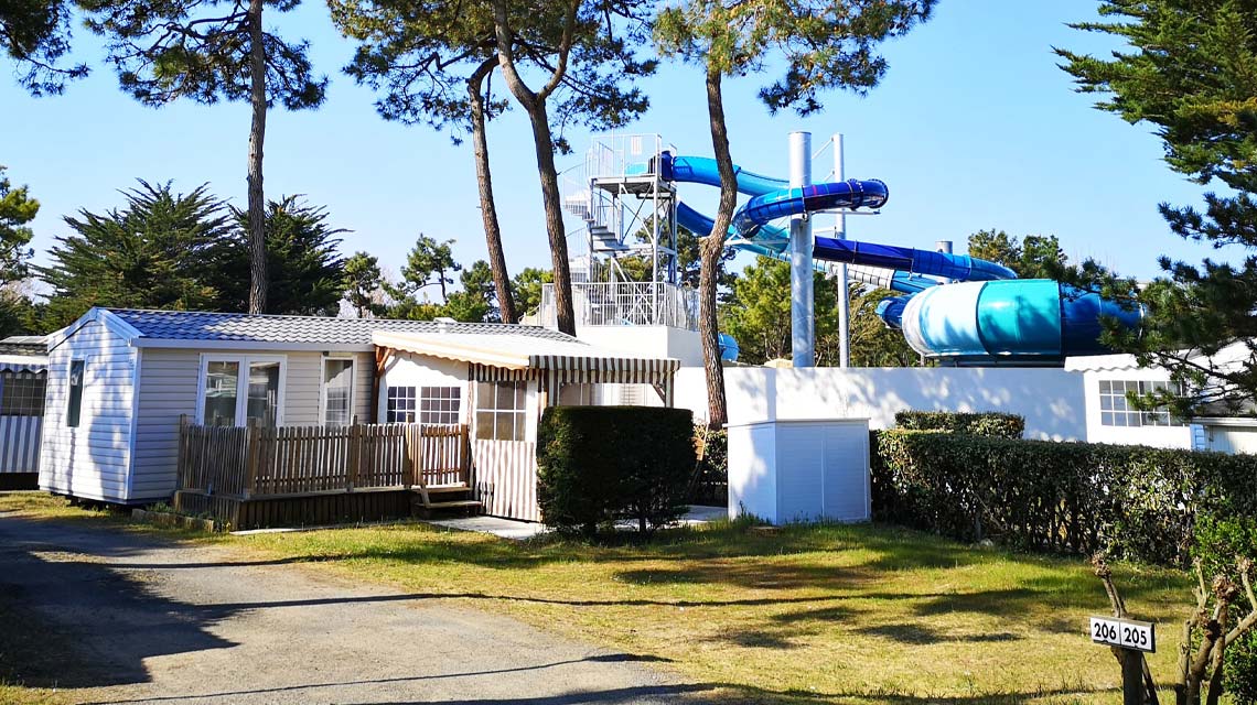 Alley of the Le Clos des Pins campsite with a view of the water slides in Saint-Hilaire