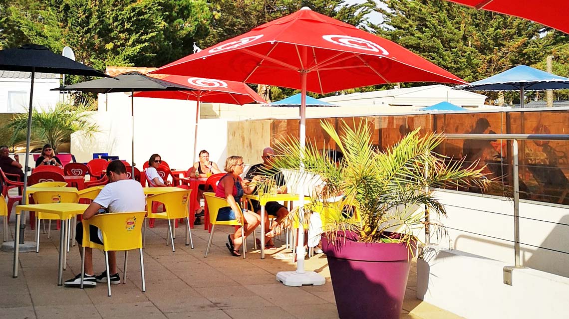 Het terras van de bar op camping Le Clos des Pins in Saint-Hilaire