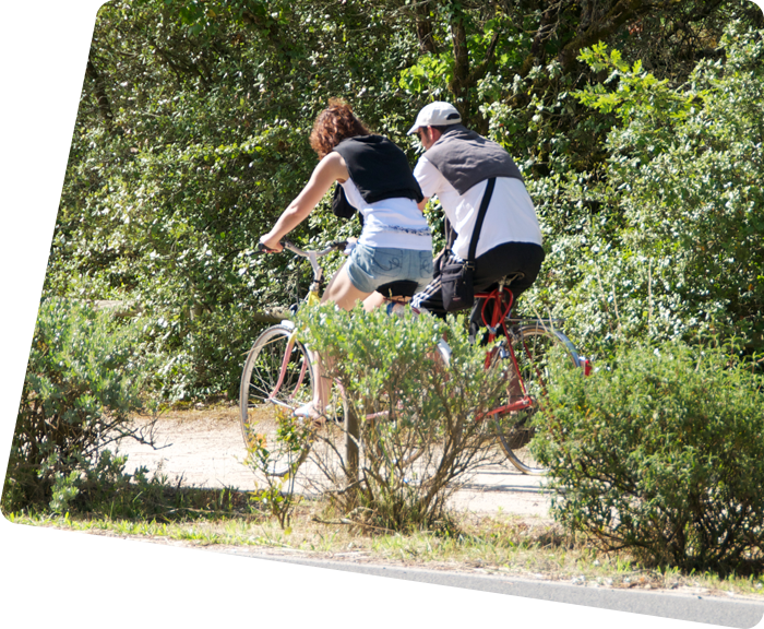 Campers cycling on a path to the beach near the campsite in Saint-Hilaire