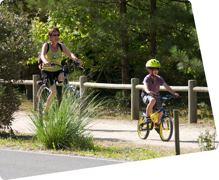 Un enfant et sa mère à vélo sur une piste cyclable près du camping à Saint-Hilaire