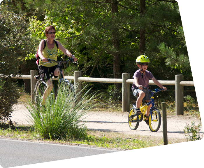 Kind en zijn moeder op een fiets in het steegje van de camping in Saint-Hilaire