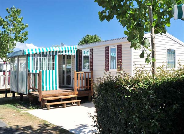 Mobil-home avec terrasse semi-couverte dans le parc du camping à Saint-Hilaire