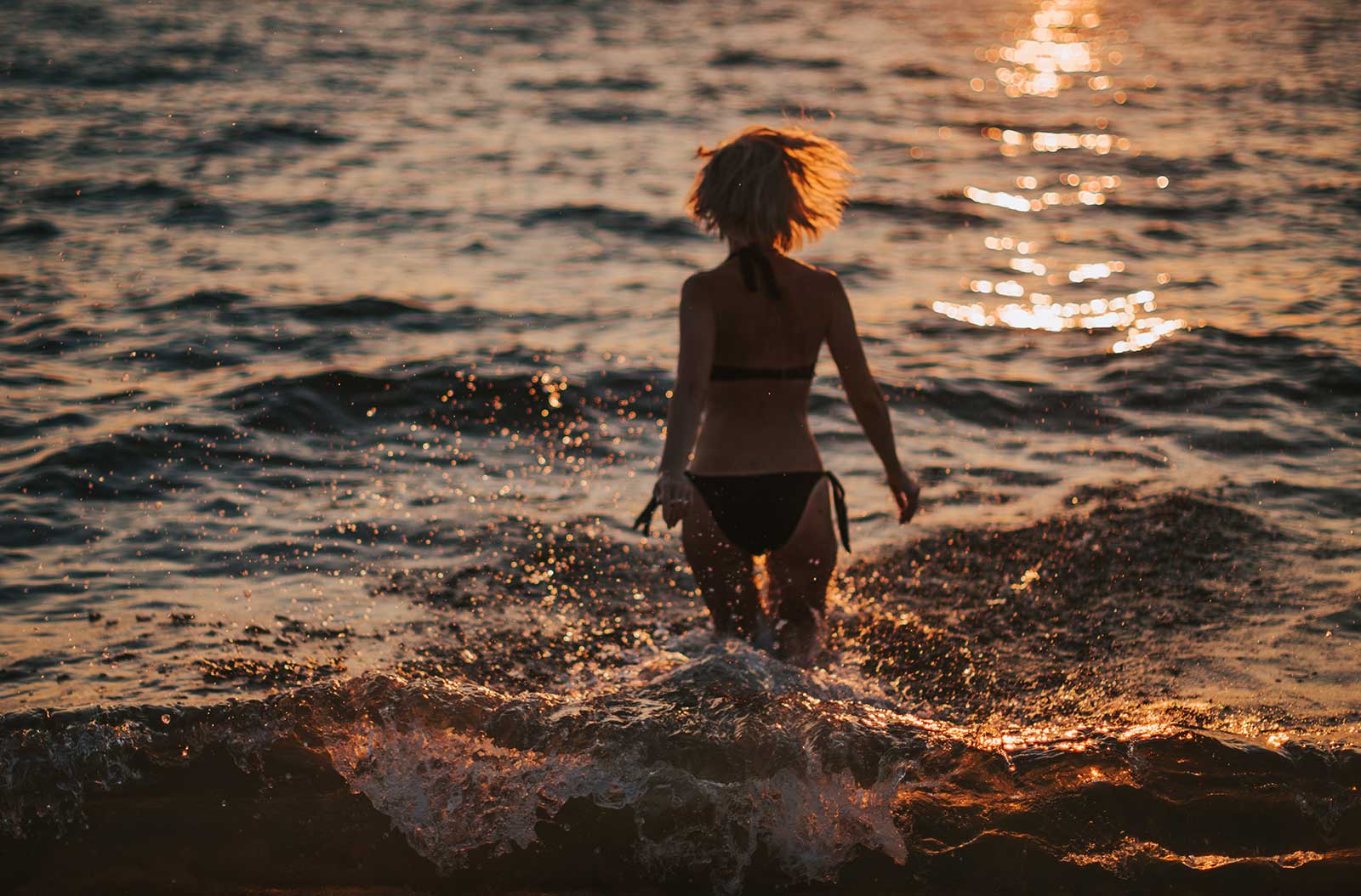 Jonge vrouw 's avonds aan het baden op het strand bij de camping in Saint-Hilaire