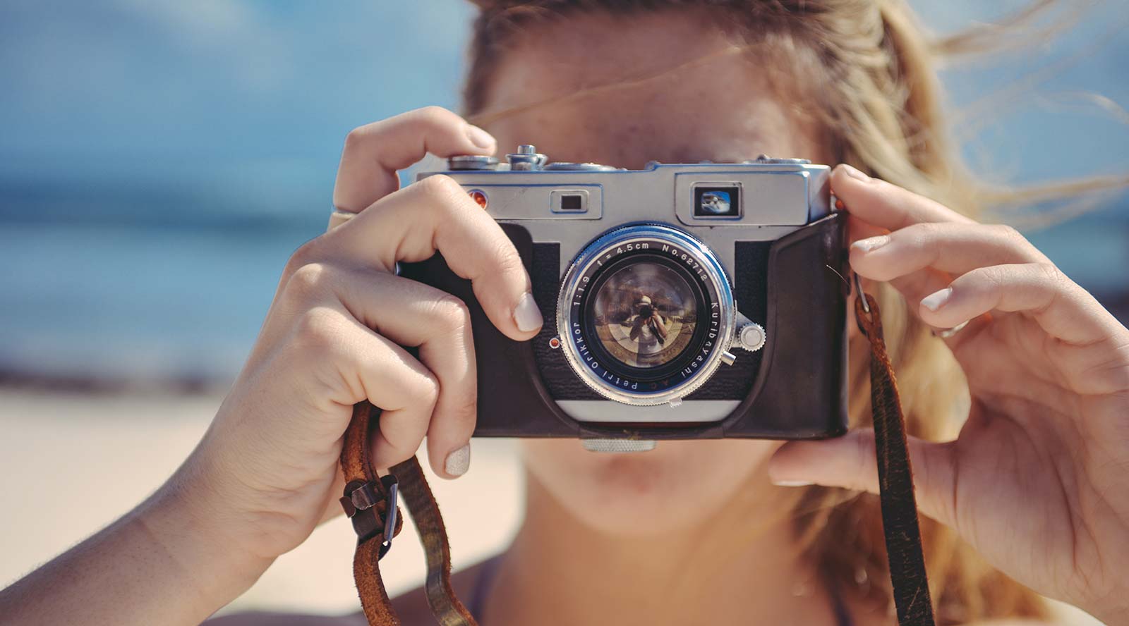 Vrouw met camera op het strand bij de camping in Saint-Hilaire