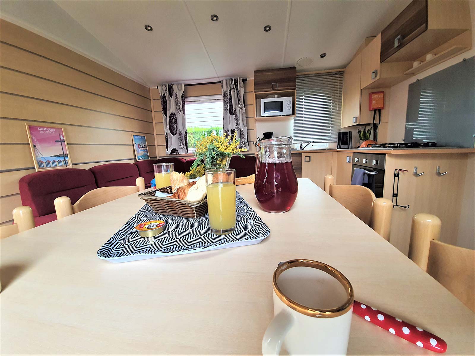 Table avec assiettes et cuisine dans un mobil-home au camping en Vendée