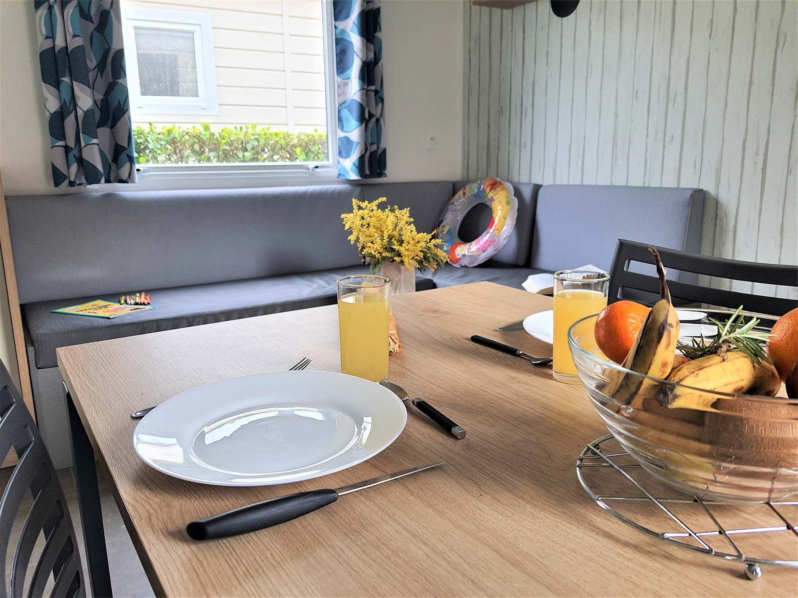 Table avec assiettes et cuisine dans un mobil-home au camping en Vendée