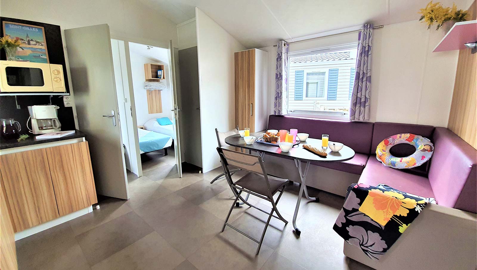 Living room with kitchenette and microwave oven in a mobile home in Saint-Hilaire