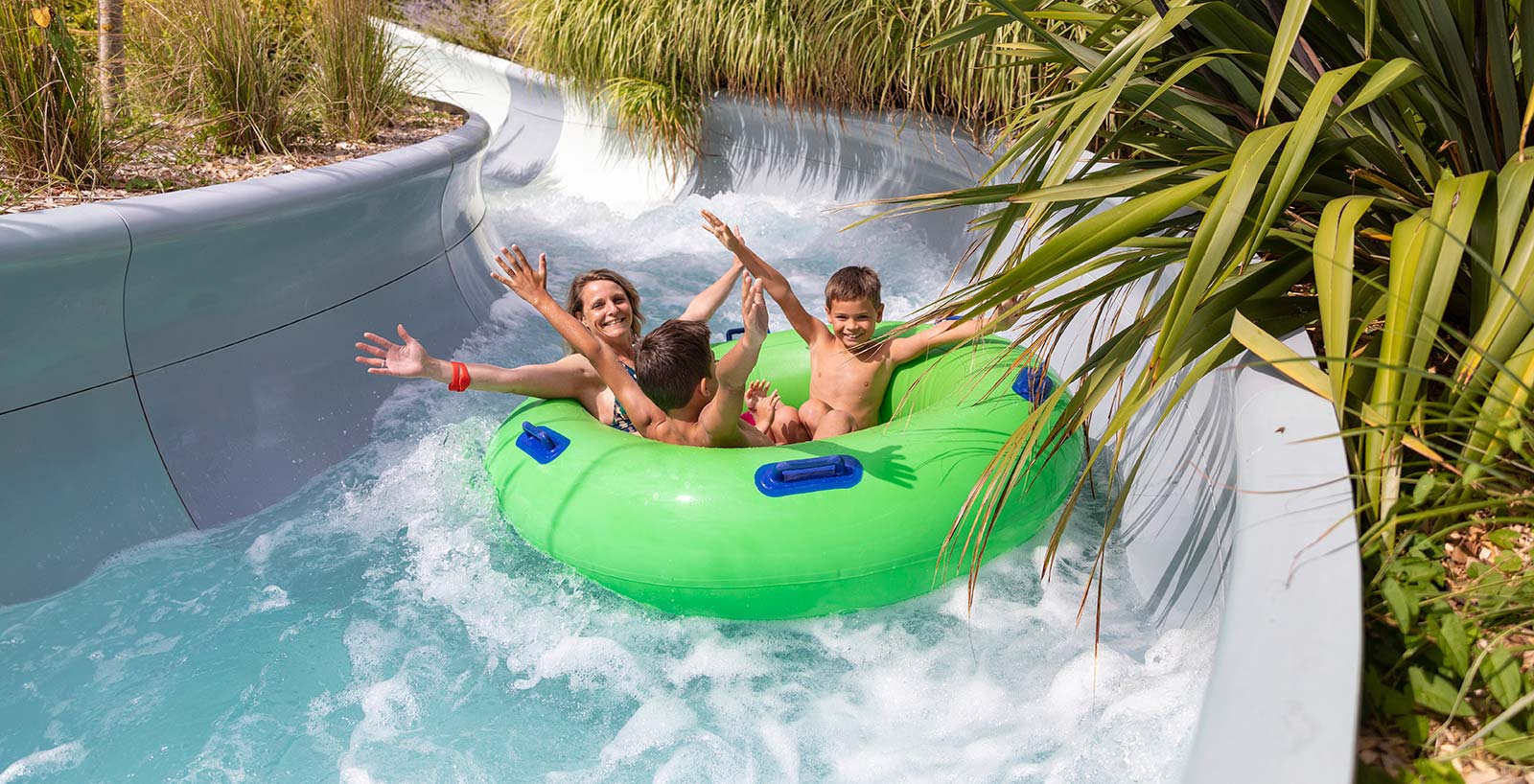 Enfants dans une bouée verte flottant dans un parc aquatique en Vendée