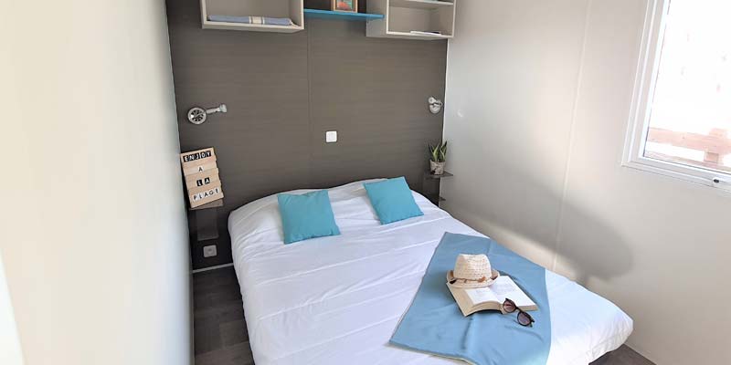 Tweepersoonsbed in de ouderslaapkamer van een stacaravan in Saint-Hilaire-de-Riez