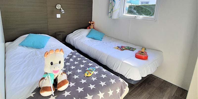 Two single beds in the bedroom of a comfort mobile home in Vendée