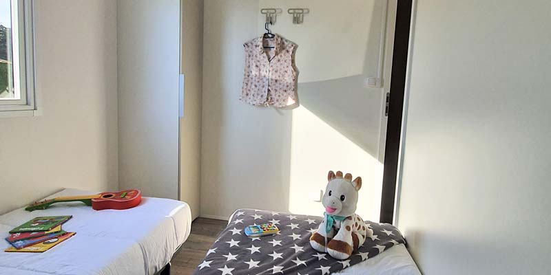 Single beds and toys in the children's room of a 6-person mobile home in Saint-Hilaire