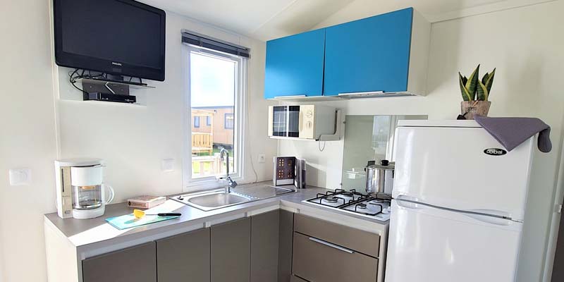 Fridge and kitchenette in a mobile home at La Plage 85 campsite