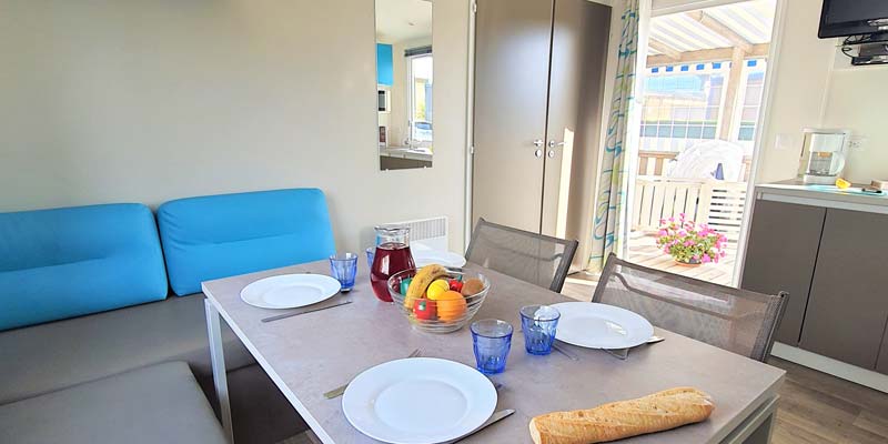 Comfortabele tafel en banken in een stacaravan in de Vendée