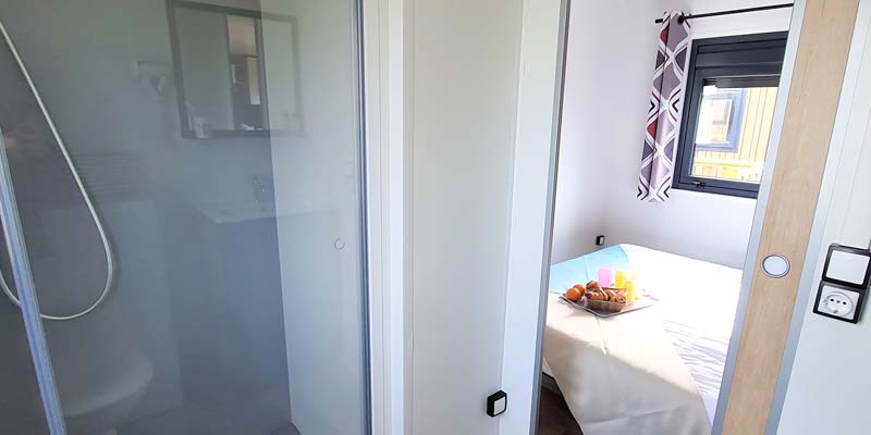 Bedroom and bathroom with shower of a mobile home at the campsite in Saint-Hilaire