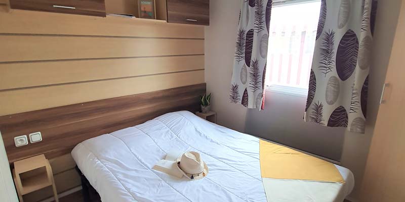 Tweepersoonsbed in de ouderslaapkamer van een stacaravan in Saint-Hilaire-de-Riez