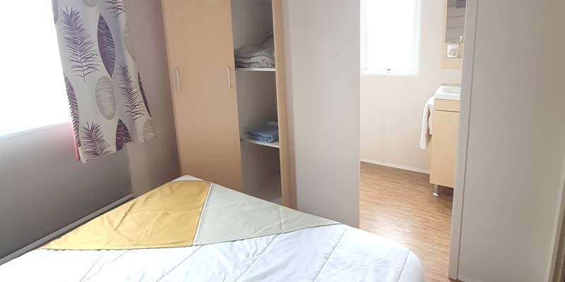 Bedroom and bathroom with shower of a mobile home at the campsite in Saint-Hilaire