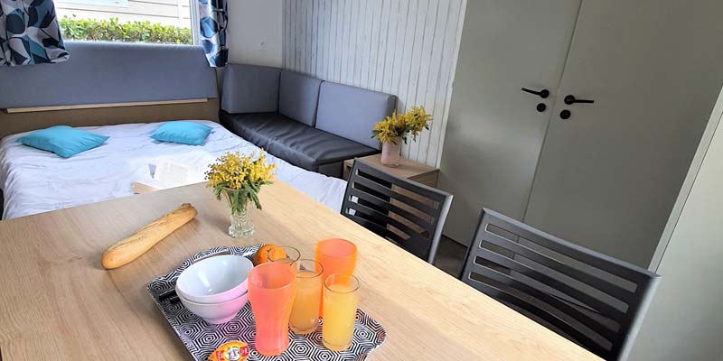 Canapé converible et table dans la pièce à vivre d'un mobil-home à Saint-Hilaire
