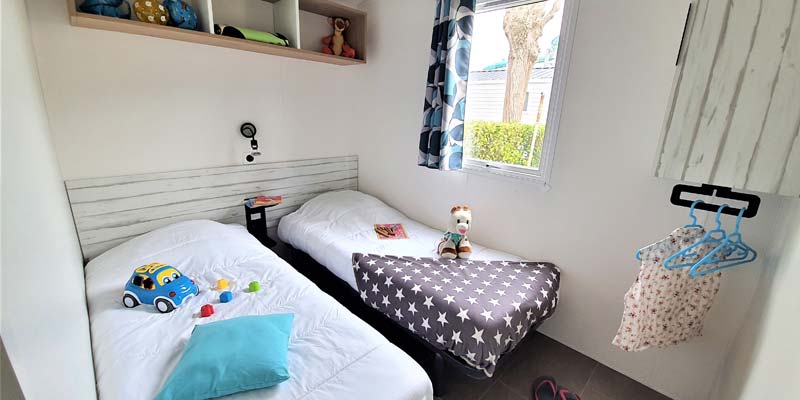 Chambre pour enfants avec deux lits et jouets dans un mobil-home en Vendée