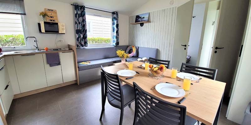 Tafel met borden en keuken in een stacaravan op de camping in de Vendée