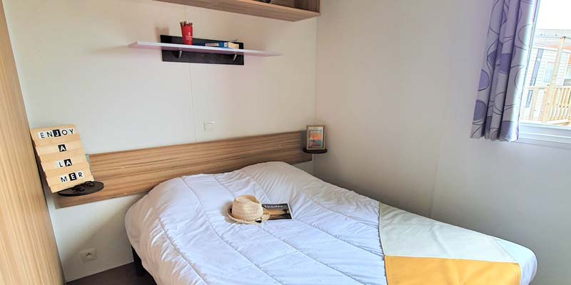 Tweepersoonsbed in de ouderslaapkamer van een stacaravan in Saint-Hilaire-de-Riez