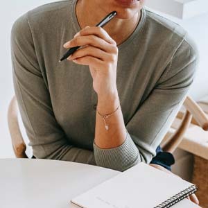 Personne avec un stylo se posant des questions sur le camping La Prairie à Saint-Hilaire