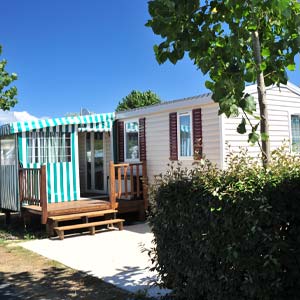 Mobil-home avec terrasse semi-couverte dans le parc du camping à Saint-Hilaire