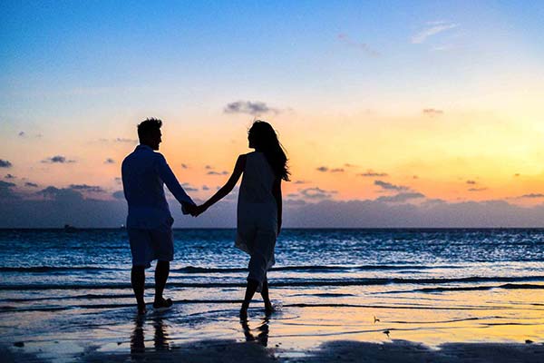 Paar hand in hand op het strand van Saint-Hilaire in de schemering