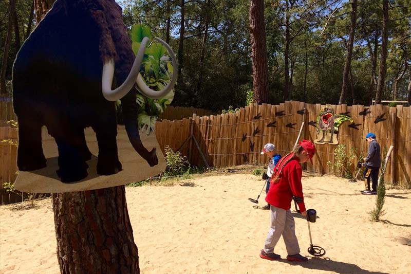 Enfants jouant sur l'aire de jeu avec un mamouth à Dinos Park en Vendée